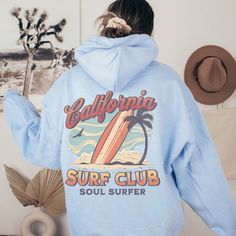 California Surf Club Hoodie, the perfect beachy sweatshirt for surf enthusiasts and coconut girls alike. This summer hoodie captures the essence of California's surf culture with its laid-back style and vibrant design. Made with high-quality materials, this surf hoodie is not only stylish but also comfortable, making it ideal for those breezy beach days or cozy nights by the bonfire. Channel your inner surfer with the California Surf Club Hoodie and embrace the carefree spirit of the California coast. 🖤 For oversized order 1-3 sizes up, refer to listing photos for sizes. RUNS ON THE SMALLER SIDE 🖤 Gildan 18500 🖤 Some Shrinkage may occur with washing 🖤 This unisex heavy blend hooded sweatshirt is relaxation itself.  🖤 Made with a thick blend of cotton and polyester, it feels plush, sof Blue Hooded Beach Tops, Blue Hooded Tops For Beach, Blue Hooded Top For Beach, Blue Hooded Tops For The Beach, Sporty Long Sleeve Sweatshirt For The Beach, Beach Hoodie With Letter Print, Casual Blue Hoodie For Beach, Blue Beach Hoodie With Letter Print, Sporty Cotton Hoodie For Beach