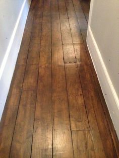 an empty hallway with wood floors and white walls