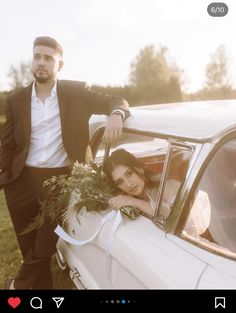 a man standing next to a woman leaning out the window of a white car in a field