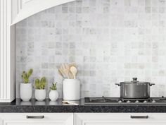 the kitchen counter is clean and ready to be used as a cooktop, with three pots on it