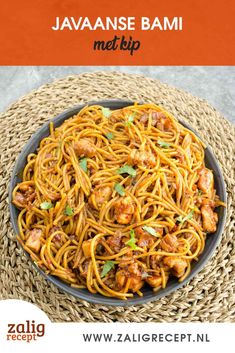 a bowl filled with noodles and meat on top of a table