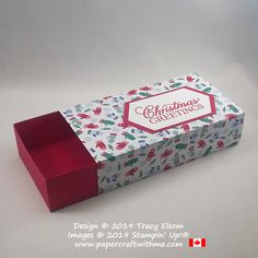 a red box with christmas greetings printed on the front and inside, sitting on a white surface