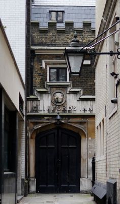 an old building with a clock on it's front door and bench in the middle