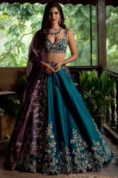 Featuring an emerald green lehenga in raw silk base with sequins embroidery. It is paired with a matching blouse and a contrasting purple organza dupatta.  FIT: Fitted at bust and waist. COMPOSITION: Raw silk, Organza. CARE: Dry clean only. Purple Lehenga, Pengantin India, Best Designer Dresses, Green Lehenga