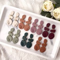 a tray with different colored earrings on it