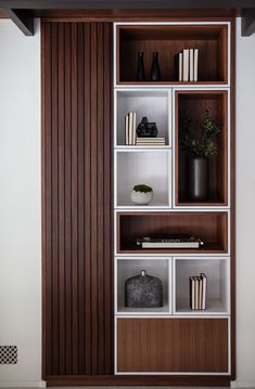 a bookshelf with several shelves and vases on top of each shelf in front of a wall