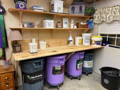 several buckets are lined up on a shelf in a room filled with other items