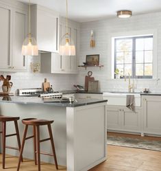 a kitchen with two stools next to an island