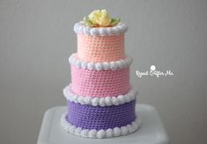 three tiered crocheted cake with flowers on top