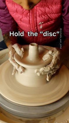 a woman is making pottery on a potter's wheel with the words hold the disc