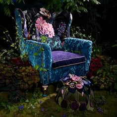 a blue chair sitting in the middle of a forest filled with lots of plants and flowers