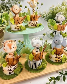 there are many small cakes decorated with animals on top of each cake platter, including zebras and giraffes