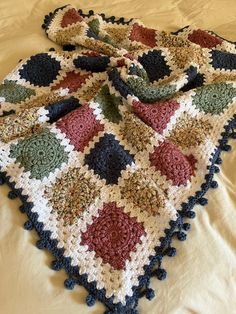 a crocheted granny afghan is laying on a bed