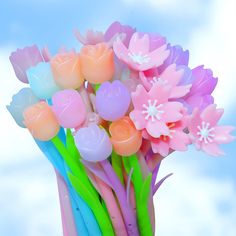 a bouquet of flowers with pastel colors on the stems in front of a blue sky