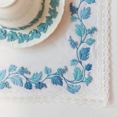 a white plate with blue flowers and leaves on it