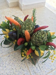 an arrangement of fruits and vegetables arranged in a vase on a tile flooring area