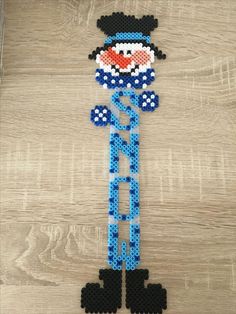 an image of a beaded snowman made out of beads on a wooden surface