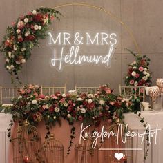 a wedding arch with flowers and birdcages in front of the sign that says mr & mrs hellmut