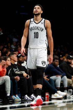 the brooklyn nets player is standing on the court in front of an audience at a basketball game