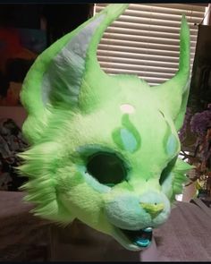 a green cat mask sitting on top of a table