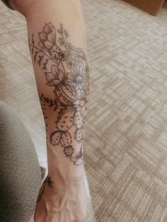 a woman's foot with flowers on it and a clock in the middle of her leg