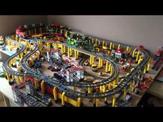 a toy train set is shown in the middle of a playroom with cars and tracks