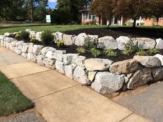 a large rock wall in front of a house