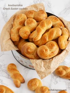 several rolls in a metal pan on a marble counter top with text overlay that reads kohluauraki greek easter cookies