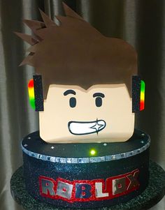 a lego head on top of a cake with lights in the ears and an electronic sound board attached to it