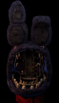 an animal made out of fake fur with its mouth open and eyes wide open in the dark