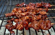 several skewered meats are being cooked on the grill