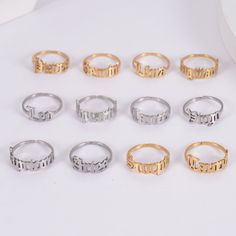 nine different types of rings sitting on top of a white table next to each other