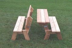 two wooden benches sitting on top of a lush green field