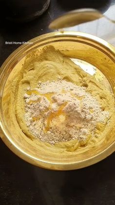 a gold bowl filled with flour on top of a table