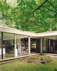 the inside of a modern house with glass walls and trees in the backgroud