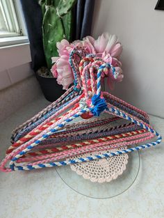 a bunch of hair ties sitting on top of a table next to a potted plant