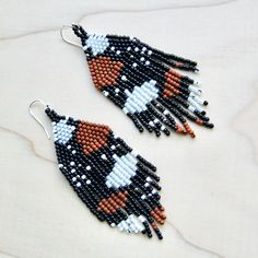 the beaded earrings are black, orange and white with an arrow on each side