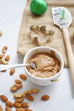 a bowl filled with peanut butter surrounded by nuts