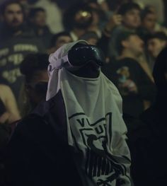 a group of people standing next to each other in front of a crowd wearing masks