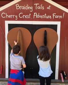 two children standing in front of a building with their hands on the back of each other