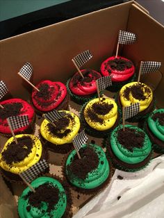 cupcakes with green and red frosting are in a box on the table