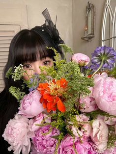 a woman holding a bouquet of flowers in front of her face