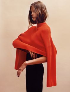 a woman wearing an orange shawl and black dress