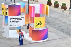 a woman standing in front of some colorful displays