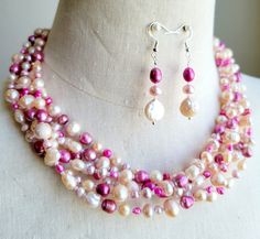 Make a real statement with this OOAK colorful necklace set. Both vintage and new freshwater pearls in shades of pink, fuchsia, and off-white cream, and glass spacer seed beads are strung on six wires and capped with decorative silver metal cones and finished with a chain and lobster clasp.  Finished length of the necklace is 20 inches long. Matching freshwater pearl earrings which are hung on 925 silver ear wires. This necklace does not include any plastic or resin materials. Pearl Cluster Necklace, Colorful Necklace, Pearl Cluster, Cluster Necklace, Freshwater Pearls Earrings, Beaded Statement Necklace, Necklace And Earring Set, Colourful Necklace, Multi Strand