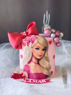 a pink cake with a barbie doll on it