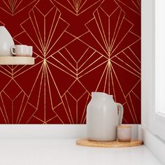 a red and gold wallpaper with white vases on the shelf next to it