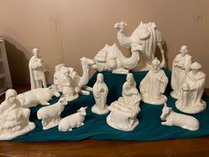 a group of white figurines sitting on top of a blue cloth covered table