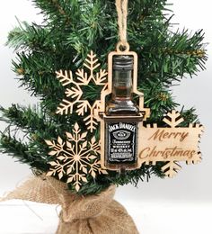 an ornament hanging from a christmas tree with a bottle of whiskey in it