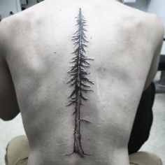 a man's back with a tree tattoo on his left side ribcage